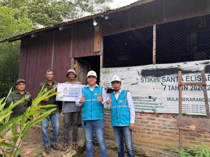 Tim PLN ULP UP3 Pematangsaintar bersama Andi Novi berfoto di depan rumahnya yang mendapat bantuan dari program Light Up The Dream. Program ini merupakan wujud kepedulian sosial insan PLN melalui donasi sukarela untuk menghadirkan terang bagi masyarakat kurang mampu.