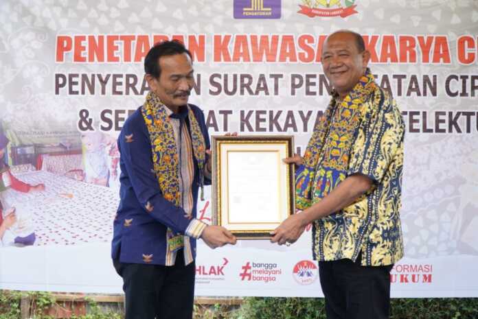 TERIMA: Bupati Langkat, Syah Afandin menerima Sertifikat Kekayaan Intelektual Komunal (KIK) dari Kakanwil Kemenkumham Sumut, Ignatius Mangantar Tua Silalahi.(Diskominfo Langkat/Sumut Pos)