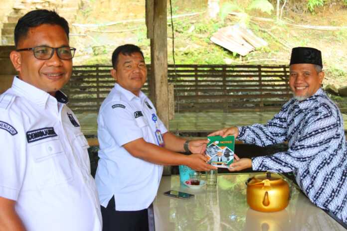 Anggota DPD RI asal Sumut Muhammad Nuh menyerahkan buku sebagai cenderamata kepada Camat Dolok, Kabupaten Padanglawas Utara, saat meninjau progres perbaikan jalan lintas Labuhanbatu-Paluta, Rabu (11/6). (Foto: Dok Pribadi Muhammad Nuh).