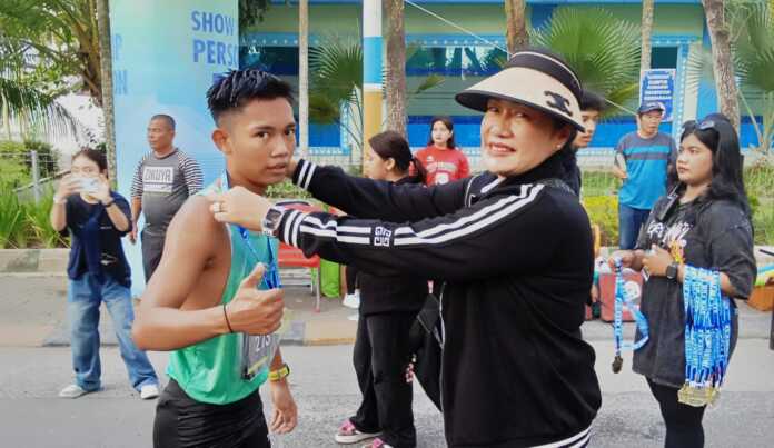 MEDALI: Dosen UMA AKBP Purn Dr Serimin Pinem MKn (kanan) mengalungkan medali pada peserta fun run di garis finish. (DEDDI MULIA PURBA/SUMUT POS)