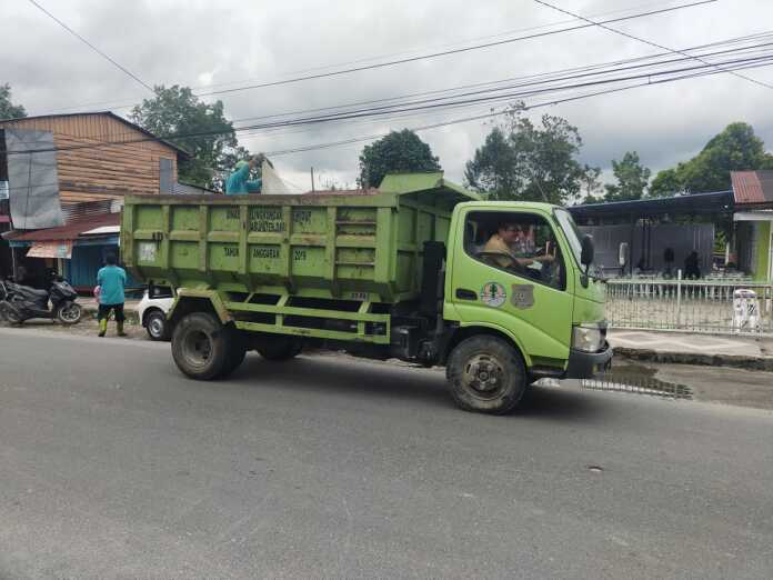 ANGKUT SAMPAH: Kepala Dinas Lingkungan Hidup Kabupaten Dairi, Sahat Maruli Tua Sinaga, jadi sopir truk sampah untuk menangani persoalan sampah di Kota Sidikalang, Selasa (15/7).(Rudy Sitanggang/Sumut Pos)