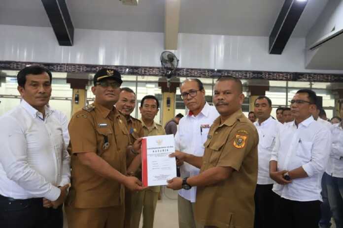 SERAHKAN SK: Wakil Bupati Dairi Wahyu Daniel Sagala (dua kiri) secara simbolis menyerahkan Akta Pendirian Koperasi Merah Putih kepada Lurah Panji Dabutar, Kecamatan Sitinjo, Haposan Bancin di Gedung Balai Budaya Sidikalang, Senin (21/7).(Istimewa)