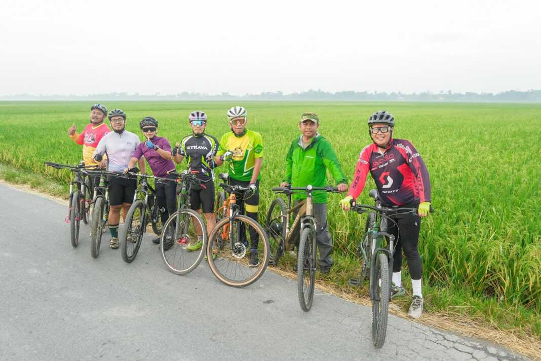 NAIK SEPEDA: Bupati Sergai Darma Wijaya alias Bung Wiwik bersama Ketua KONI Usman Efendi Sitorus bersepeda sekaligus tinjau sawah dan temui petani, Sabtu (26/7).