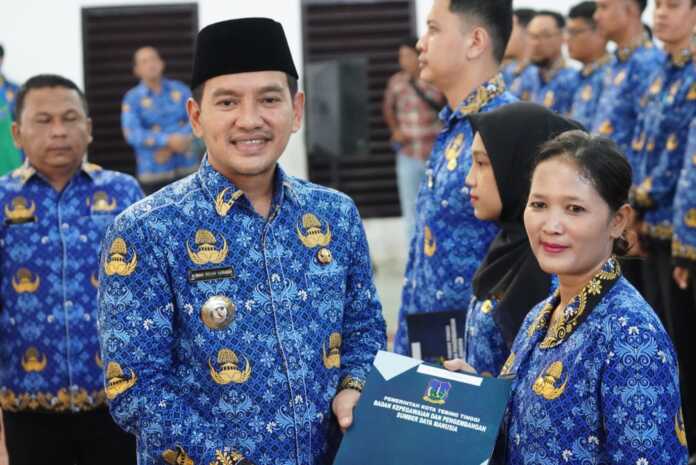 SERAHKAN SK: Wali Kota Tebingtinggi Iman Irdian Saragih memberikan SK PPPK kepada salah seorang pegawai Kota Tebingtinggi di Gedung Olahraga Asber Nasution Jalan Gunung Lauser Kota Tebingtinggi.(ISTIMEWA/SUMUT POS)