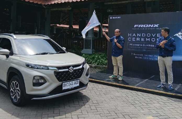 Lepas: Operatation Manager PT Arista Sukses Abadi, Stepanus Ginting, SE (kiri), melepas bendera sebagai tanda pemberian mobil Suzuki Fronx kepada 10 konsumen pertama Sabtu (12/7/2025).