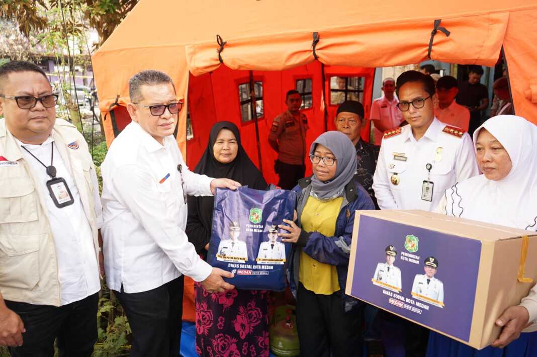 BANTUAN: Rico Wass saat memberikan bantuan kepada korban kebakaran di Jalan Tuba II.