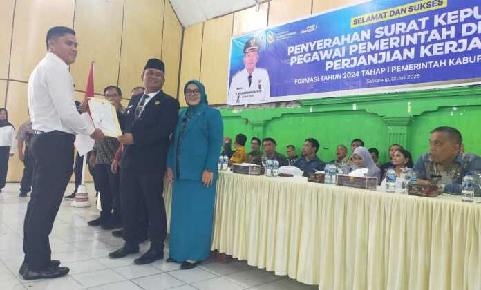 SERAHKAN: Wakil Bupati Dairi Wahyu Daniel Sagala, didampingi Sekda Surung Charles Lamhot Bantjin, Kepala BKPSDM Junihardi, secara simbolis menyerahkan SK pengangkatan kepada PPPK Formasi 2024 Tahap Pertama di GOR Sidikalang, Kamis (31/7).(Rudy Sitanggang/Sumut Pos)
