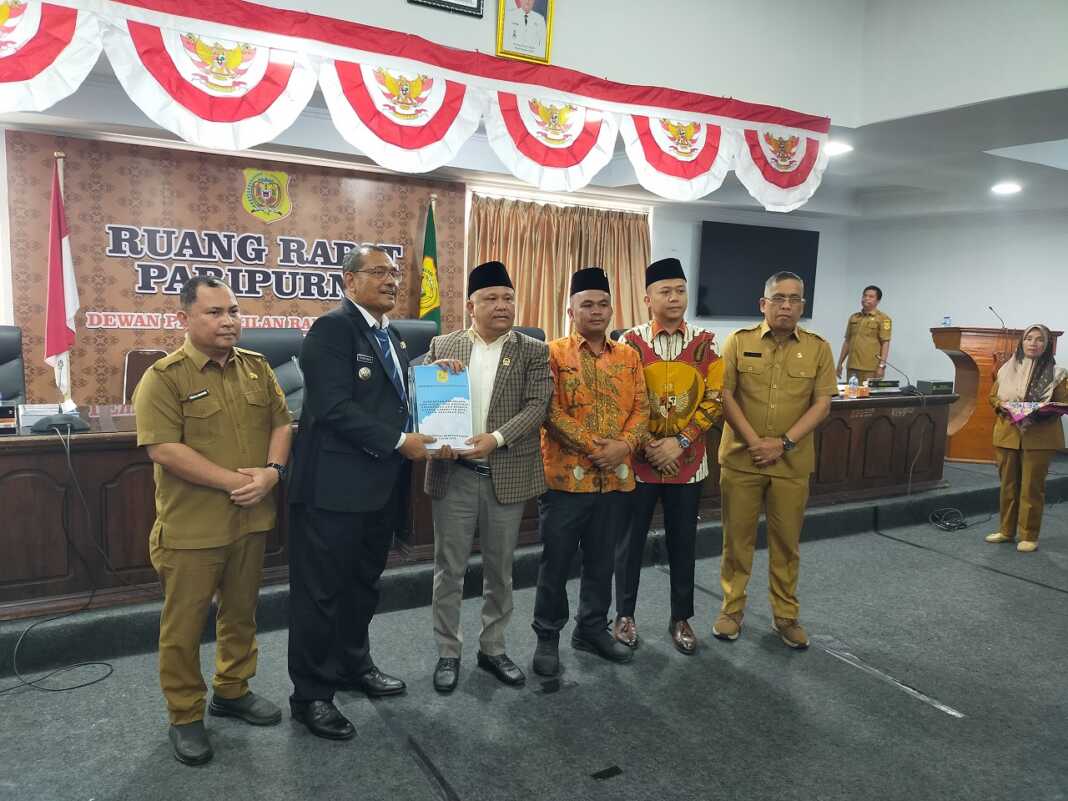 SERAHKAN: Bupati Dairi Vickner Sinaga, saat menyerahkan Rancangan KUA-PPAS TA 2025 kepada Ketua DPRD Dairi Sabam Sibarani, saat menyampaikan nota pengantar, Selasa (23/9).(Rudy Sitanggang/Sumut Pos)