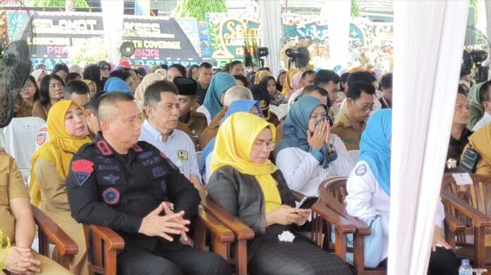 MAIN HP: Ketua DPRD Binjai Kristiana Gusuartini br Surbakti (tengah, pakai kacamata) sibuk bermain HP saat Sekdaprov Sumut Togap Simangunsong, menyampaikan sambutan pada Peluncuran Program Universal Health Coverage (UHC).(Teddy Akbari/Sumut Pos)