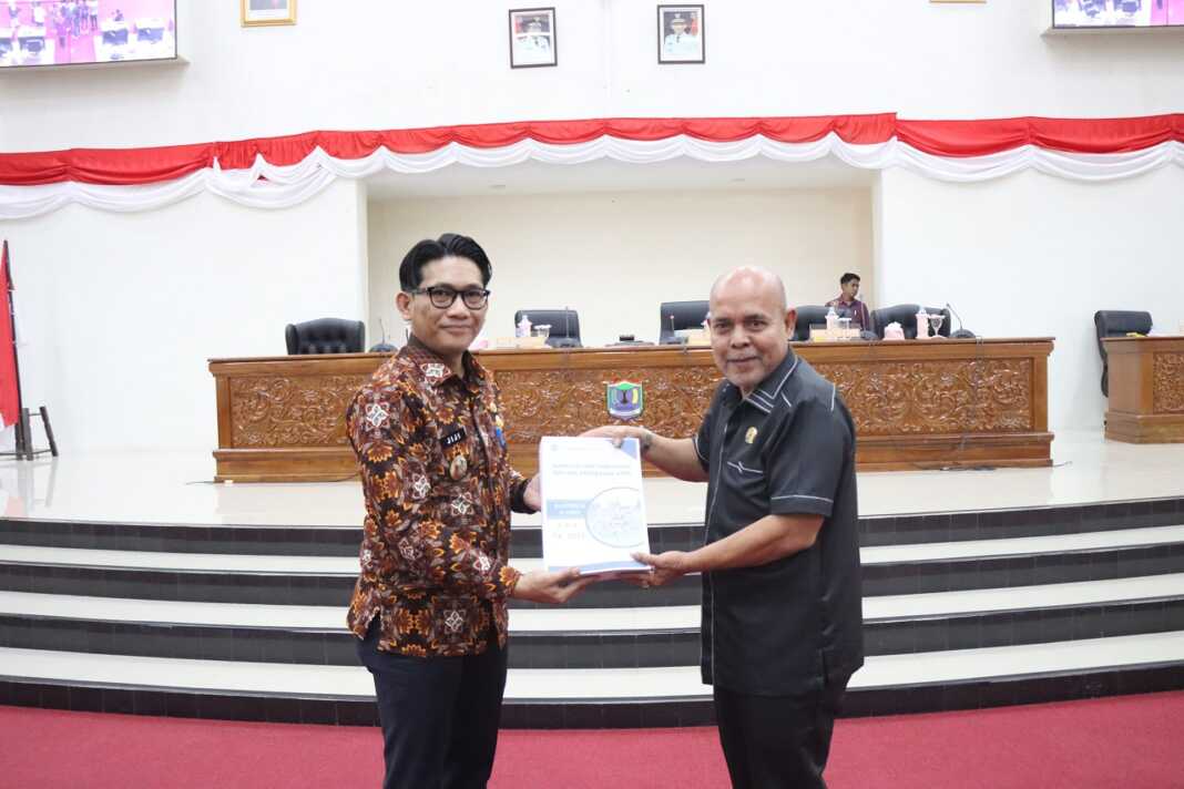 SERAHKAN: Wakil Wali Kota Binjai Hasanul Jihadi (kiri) menyerahkan dokumen Ranperda Perubahan-APBD TA 2025 kepada Wakil Ketua DPRD Juli Sawitma Nasution.(Dokumen Diskominfo Binjai)