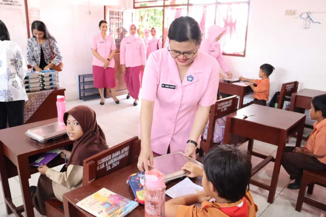 Ketua Yayasan Kemala Bhayangkari Cabang Labuhanbatu, Rina, saat memberikan makanan bergizi kepada seorang siswa di di Sekolah Kemala Bhayangkari 2, Jalan Skip Rantauprapat, Kecamatan Rantau Utara, Jumat (26/9).( Fajar/Sumut Pos)