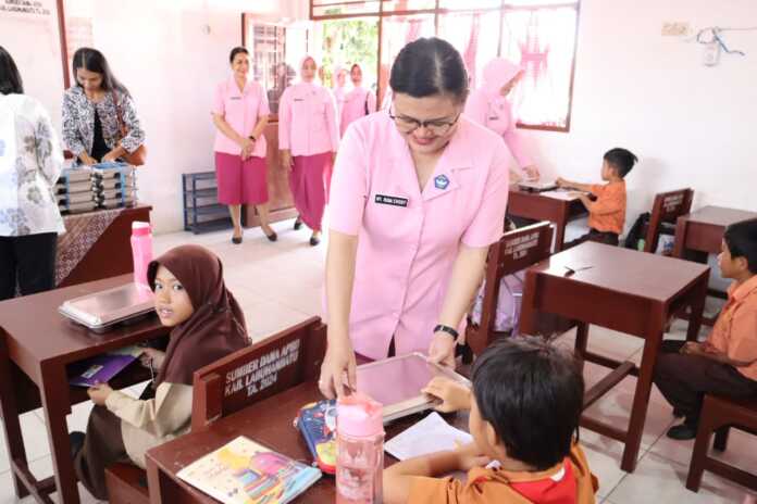 Ketua Yayasan Kemala Bhayangkari Cabang Labuhanbatu, Rina, saat memberikan makanan bergizi kepada seorang siswa di di Sekolah Kemala Bhayangkari 2, Jalan Skip Rantauprapat, Kecamatan Rantau Utara, Jumat (26/9).( Fajar/Sumut Pos)