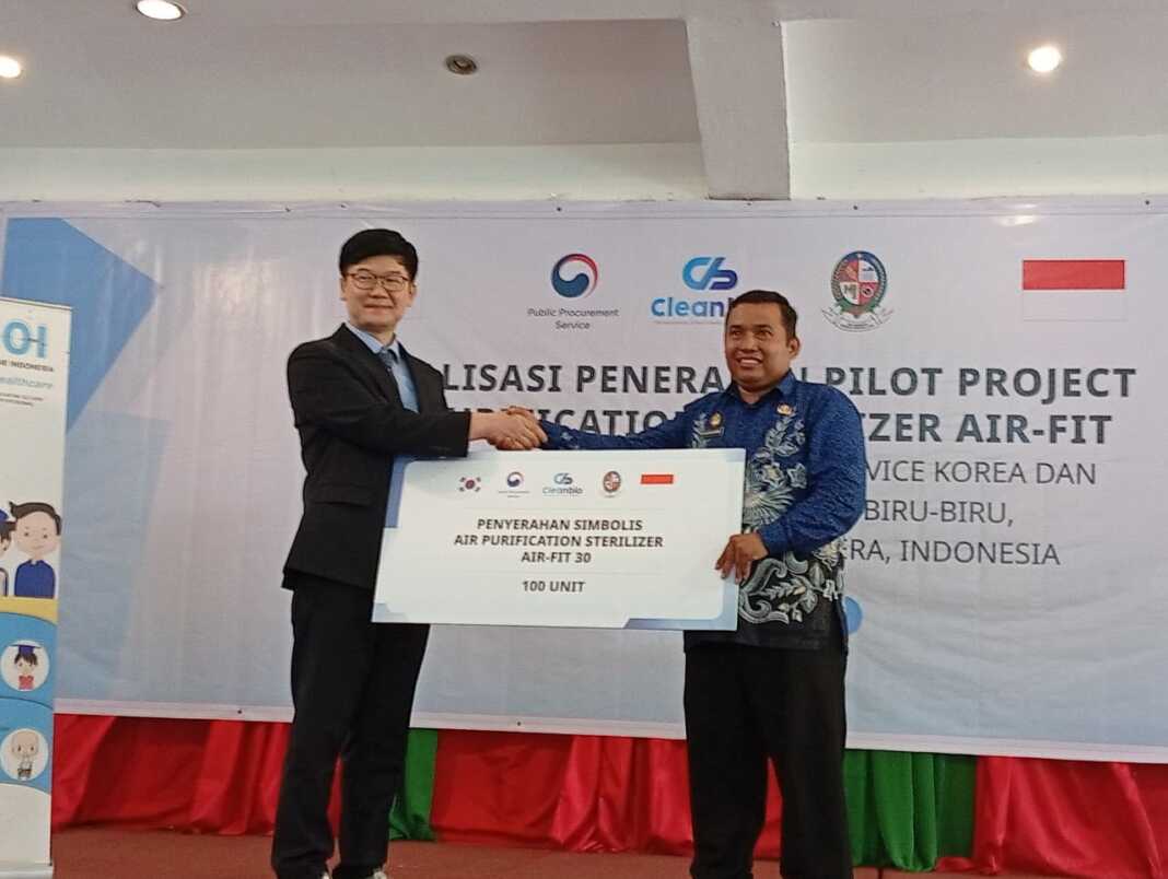 SERAHKAN: Director of Research dari Clean Bio, Kyongshin Park menyerahkan air sterilizer Air Fit kepada Kepala Desa Rumah Gerat, Pengarapen Ginting di di Kenanga Garden, Jumat (18/9/2025). (Dok Pribadi)