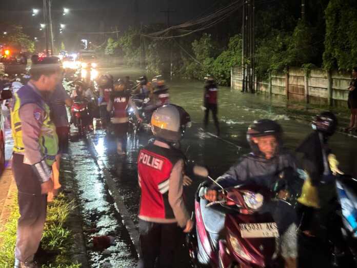 BANJIR: Pengendara terjebak macet akibat banjir yang menggenang Jalan Sisingamangaraja Meda, Minggu (12/10) malam.