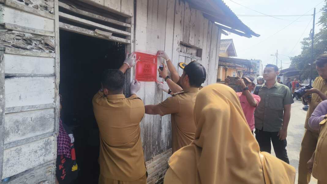 TANDAI RUMAH: Wali Kota Tebintinggi Iman Irdian Saragih melebel rumah warga yang menerima bantuan PKH, Selasa (14/10)