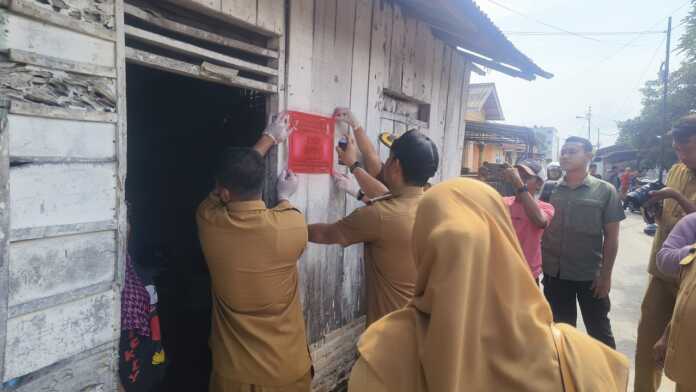 TANDAI RUMAH: Wali Kota Tebintinggi Iman Irdian Saragih melebel rumah warga yang menerima bantuan PKH, Selasa (14/10)
