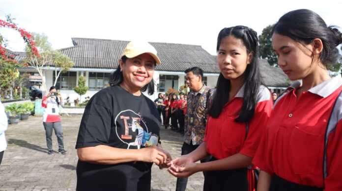 SERAHKAN: Ketua TP PKK Dairi Rita Puspita Situmorang (kiri) saat menyerahkan tablet vitamin kepada pelajar SMKN 1 Sidikalang, Kamis (16/10).