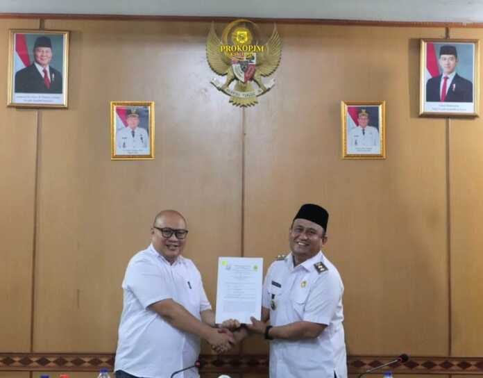 SERAHKAN: Wakil Bupati Dairi Wahyu Daniel Sagala, saat menyerahkan dokumen hibah tanah dan bangunan kepada Kepala Kejari Dairi Cahyadi Sabri, Rabu (22/10).(Istimewa)