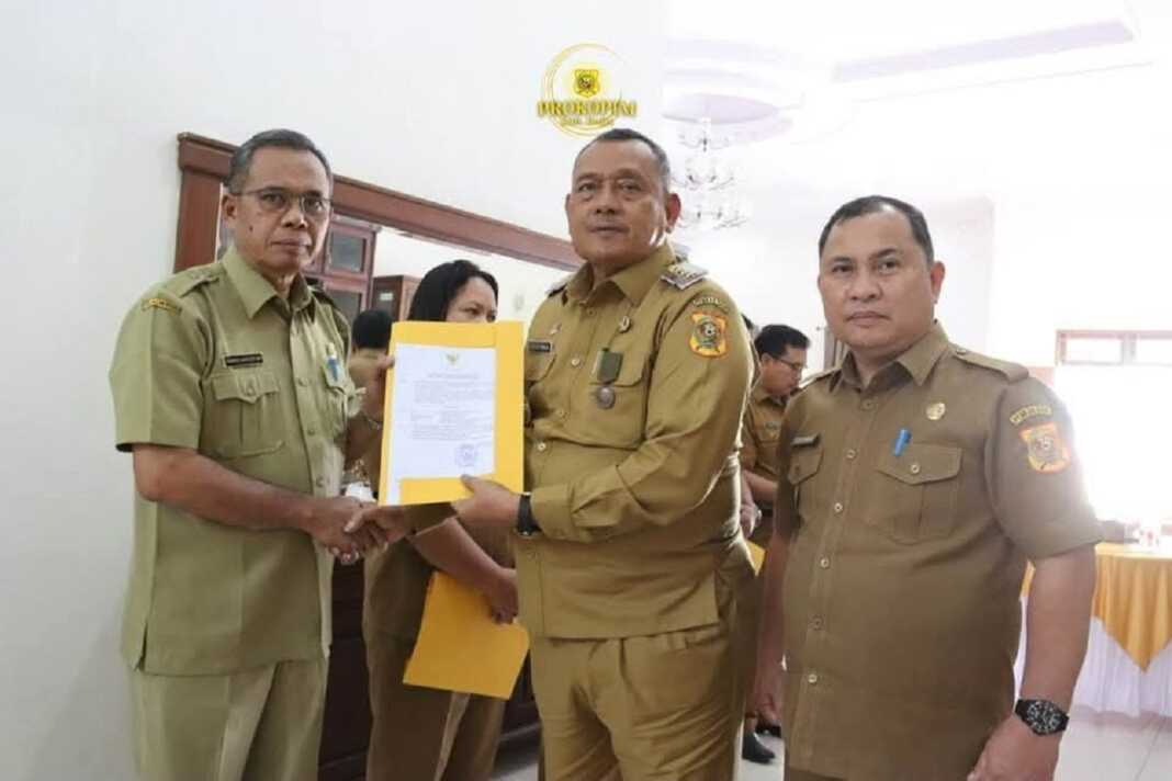 SERAHKAN: Bupati Dairi Vickner Sinaga (tengah) didampingi Sekdakab Dairi Surung Charles Lamhot Bantjin, saat menyerahkan SK Plt kepada Ramses Nainggolan.(Rudy Sitanggang/Sumut Pos)