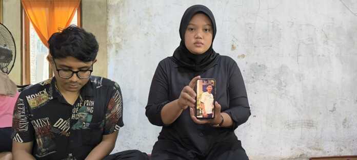 TUNJUKKAN: Adik Argo Prasetyo, Ega Prasetya (kanan) saat menunjukkan foto korban semasa hidup di kediaman mereka, Desa Karang Rejo, Kecamatan Stabat, Kabupaten Langkat.(Teddy Akbari/Sumut Pos)