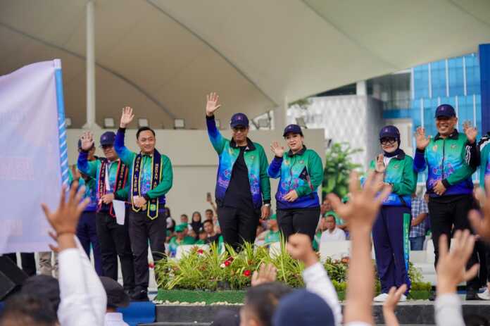 Wali Kota Medan Rico Waas didampingi Ketua TP PKK Kota Medan Airin Rico Waas dan Ketua Umum KONI Kota Medan Aswindy Fachrizal SE dan undangan menyambut defile peserta Porkot Medan 2025. (Dok KONI Medan)