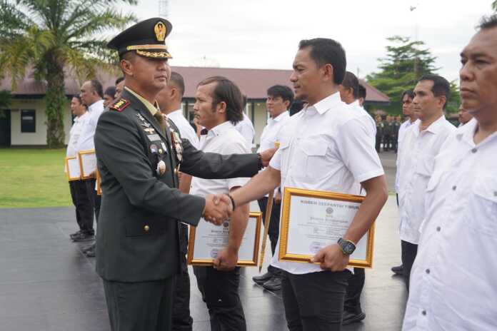 BERIKAN: Danrem 022/PT Kolonel Inf Sandi Kamidianto saat memberikan piagam penghargaan kepada personel jajaran di Lapangan Jenderal Soedirman Makorem 022/PT, Jalan Asahan Km 3,5, Kecamatan Siantar, Kabupaten Simalungun.