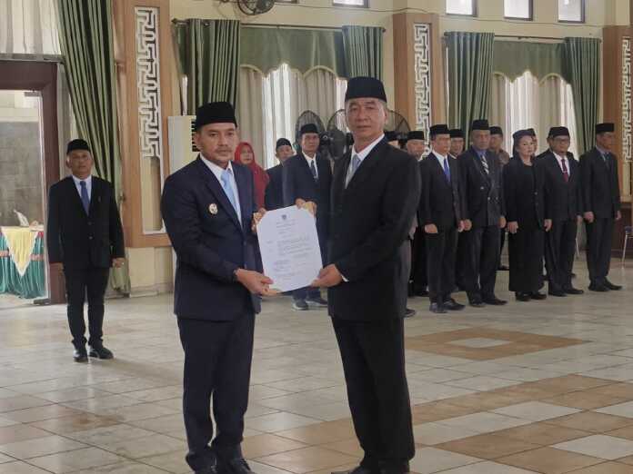 SERAHKAN: Wali Kota Tebingtinggi Iman Irdian Saragih, menyerahkan surat keputusan pelantikan kepada Erwin Suheri Damanik yang resmi menjabat Sekdako Tebingtinggi, Senin (10/11).(Azan Purba/Sumut Pos)