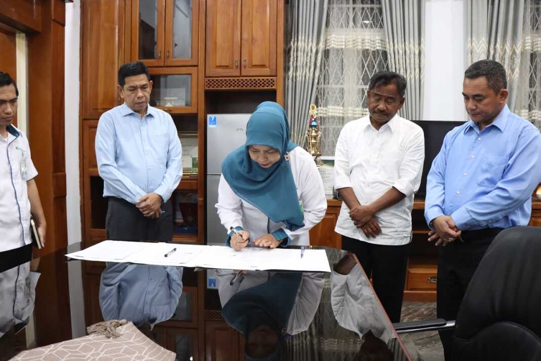 TANDA TANGAN: Kepala BPJS Ketenagakerjaan Cabang Binjai Syarifah Wan Fatimah, saat melakukan penandatanganan MoU untuk melindungi pekerja rentan.(Dokumen Diskominfo Binjai)