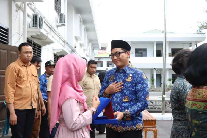 CENDERAMATA: Wakil Wali Kota Binjai Hasanul Jihadi, saat memberikan cenderamata kepada anggota Korpri yang purnatugas.(Dokumen Diskominfo Binjai)