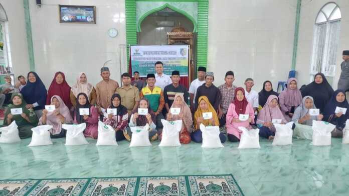 BAZNAS Batubara Salurkan Zakat Untuk Warga Desa Tanjung Kubah, Kecamatan Air Putih BERSAMA: Wakil Ketua II BAZNAS Batubara H Nasrullah, staf pelaksana, dua kelompok tani dan Sekdes Tanjungkubah Mhd Riadi foto bersama warga mustahik di Masjid Desa Tanjungkubah. (File foto Baznas Batubara)