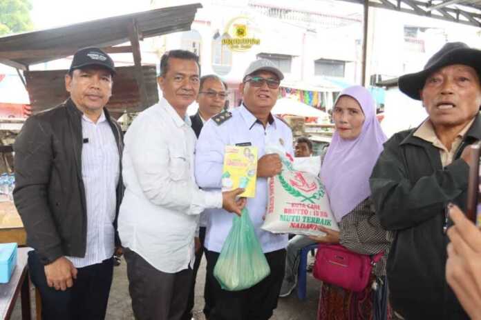 SALURKAN: Wakil Bupati Dairi Wahyu Daniel Sagala dan jajaran terkait, saat menyalurkan bantuan kepada pedagang korban kebarakan di Pusat Pasar Sidikalang, Rabu (26/11).(Istimewa)