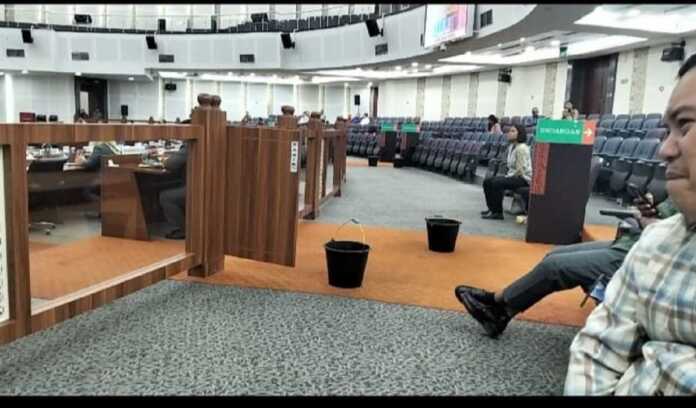 Ruang Sidang Paripurna DPRD Sumut tampak ember berserakan di lantai akibat tetesan air dari atap bocor saat Sidang Paripurna berlangsung, Kamis (27/11).