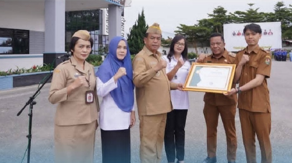 TERIMA: Fadhly Rinaldy, Agen Pesiar Terbaik 2025, saat menerima penghargaan dari Bupati Karo Antonius Ginting.(Istimewa)