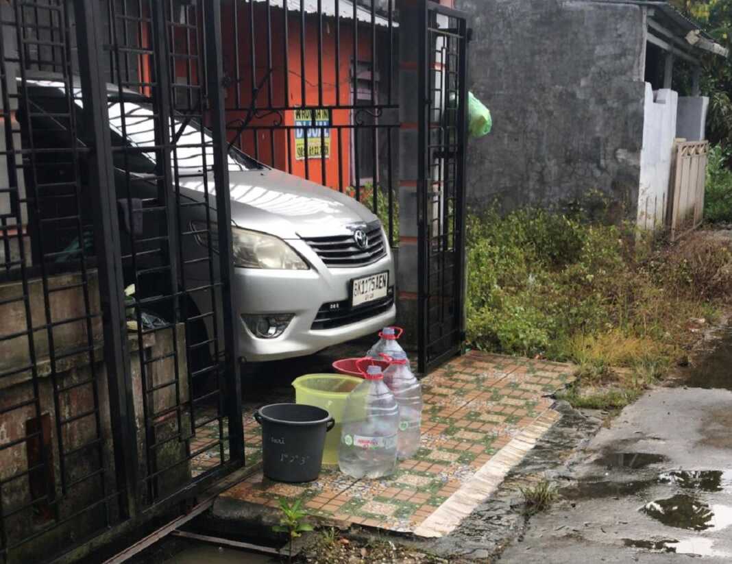 TAMPUNG AIR HUJAN: Warga Jalan Markisa 12 Blok A terpaksa menunggu hujan turun di saat mendung, Minggu (15/11).