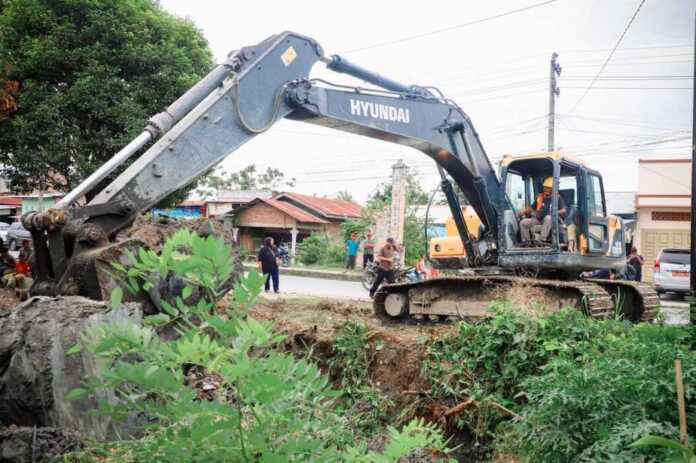 KERUK: Satu unit alat berat backhoe saat mengeruk drainase di Jalan Datuk Kabu, Pasar 3 Tembung, Kecamatan Percut Seituan, Sabtu (20/12).(Istimewa)
