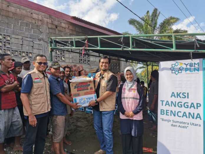 BANTUAN: Ketua YBM PLN UIP Sumbagut Bayu Wisatrioda, bersama Amil YBM PLN UIP Sumbagut Rusdi Saleh Koto, saat memyalurkan bantuan kemanusiaan bagi masyarakat terdampak banjir di Dusun III Bagan Udang, Desa Pematang Cengal, Kecamatan Tanjung Pura.
