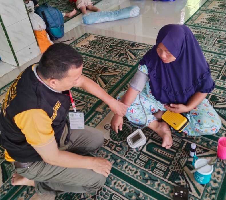 PERIKSA: Tim medis RS Haji Medan saat memeriksa kesehatan pengungsi bencana banjir dan longsor di Sibolga.