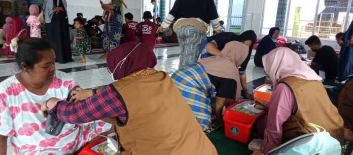 Pemeriksaan Kesehatan dan Pengobatan oleh tim Medis di Kampung Kota Lintang, Kecamatan Kota Kualasimpang, Aceh Tamiang dengan latar belakang program Trauma Healing, Kolaborasi pelayanan korban banjir dari AQL Laznaz Peduli, FUIB dan JATI, Sabtu (24/1/2026). Foto: Istimewa