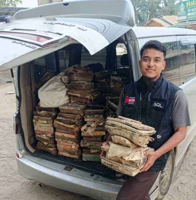 Ustadz Mukhlis, relawan AQL Laznas Peduli dari Pesantren Ibadurrahan Stabat yang sedang mengumpulkan musaf-musaf yang hancur karena banjir lumpur. Foto: Dok AQL Laznas