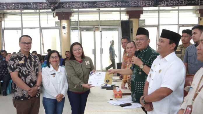 SERTIFIKAT: Bupat i Dairi Ir Vickner Sinaga didampingi Wabup Wahyu Daniel Sagala serahkan sertifat kepada Kepala Desa usai memimpin rapat kerja refleksi 1 tahun kepemimpinanya di gedung Balai Budaya Sidikalang, Jumat (20/2).(SUMUT POS/istimewa)