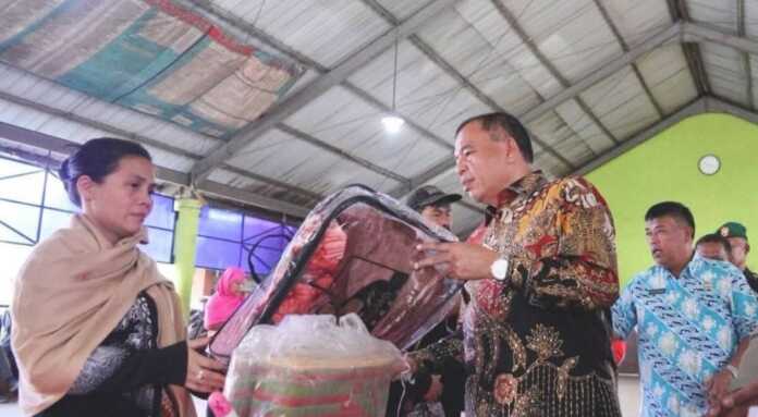 SERAHKAN: Bupati Karo menyerahkan bantuan ke warga yang jadi korban kebakaran