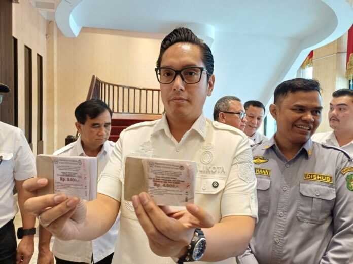 KARCIS: Wali Kota Medan Rico Tri Putra Bayu Waas menunukkan karcis tarif baru parkir tepi jalan. (Markus Pasaribu/Sumut Pos)