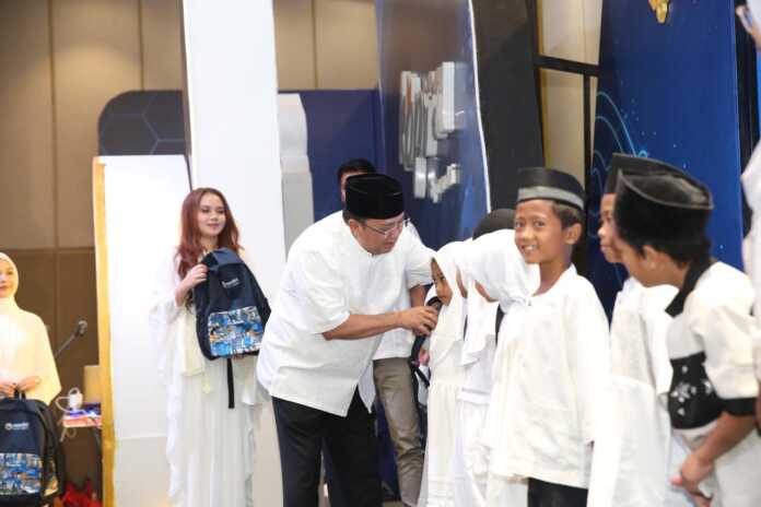 Direktur Utama Bank Mandiri, Riduan memberikan bingkisan perlengkapan sekolah kepada perwakilan anak-anak dari Panti Asuhan pada kegiatan Buka Puasa Bersama dan Santunan Anak Yatim di Gedung Menara Mandiri Regional 1/Sumatera 1, Jalan Pulau Pinang Medan, Selasa (24/2).