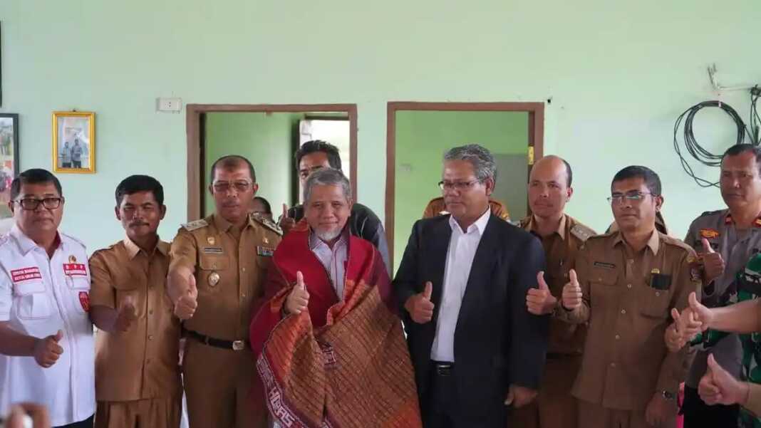 Wakil Bupati Toba Audi Murphy O Sitorus menyematkan kain Ulos kepada Anggota DPD RI KH Muhammad Nuh ketika melakukan reses di Geo Wisata Pantai Pasifik, Kecamatan Porsea, Kabupaten Toba, Senin (23/2). Foto: Istimewa