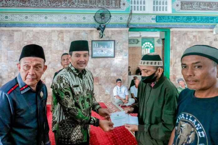 PENYERAHAN: Wali Kota Tebingtinggi H Iman Irdian Saragih menyerahkan secara simbolis bantuan zakat Ramadhan kepada mustahik pada kegiatan penyaluran zakat oleh BAZNAS Kota Tebingtinggi di Masjid Raya Nur Addin, Jalan MT Haryono, Kamis (12/3) Azan Purba/sumut pos.