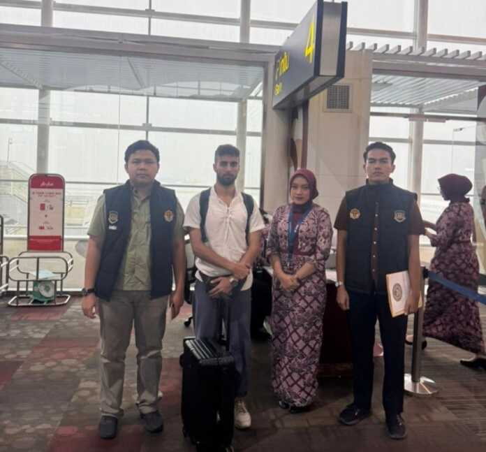 DEPORTASI: Petugas Kantor Imigrasi Kelas II TPI Belawan saat mendeportasi warga negara Belgia yang terbukti melanggar aturan keimigrasian.