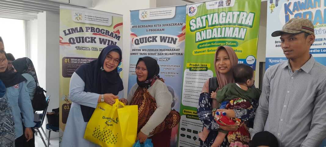 BINGKISAN: Kepala Perwakilan BKKBN Provinsi Sumut Dr Fatmawati saat memberikan bingkisan kepada pemudik, di Stasiun KAI Medan.(Dewi Syahruni Lubis/Sumut Pos)