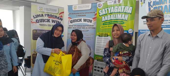 BINGKISAN: Kepala Perwakilan BKKBN Provinsi Sumut Dr Fatmawati saat memberikan bingkisan kepada pemudik, di Stasiun KAI Medan.(Dewi Syahruni Lubis/Sumut Pos)