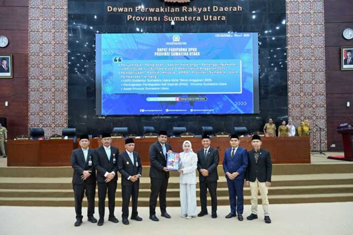 SERAHKAN LKPJ: Gubernur Sumut Bobby Nasution menyampaikan dan menyerahkan Penjelasan Laporan Keterangan Pertanggung Jawaban (LKPJ) Akhir Tahun 2025 kepada Ketua DPRD Sumut Erni Ariyanti Sitorus, pada Sidang Paripurna DPRD Sumut di Ruang Rapat Paripurna DPRD Sumut, Jalan Imam Bonjol, Medan, Senin (30/3/2026).