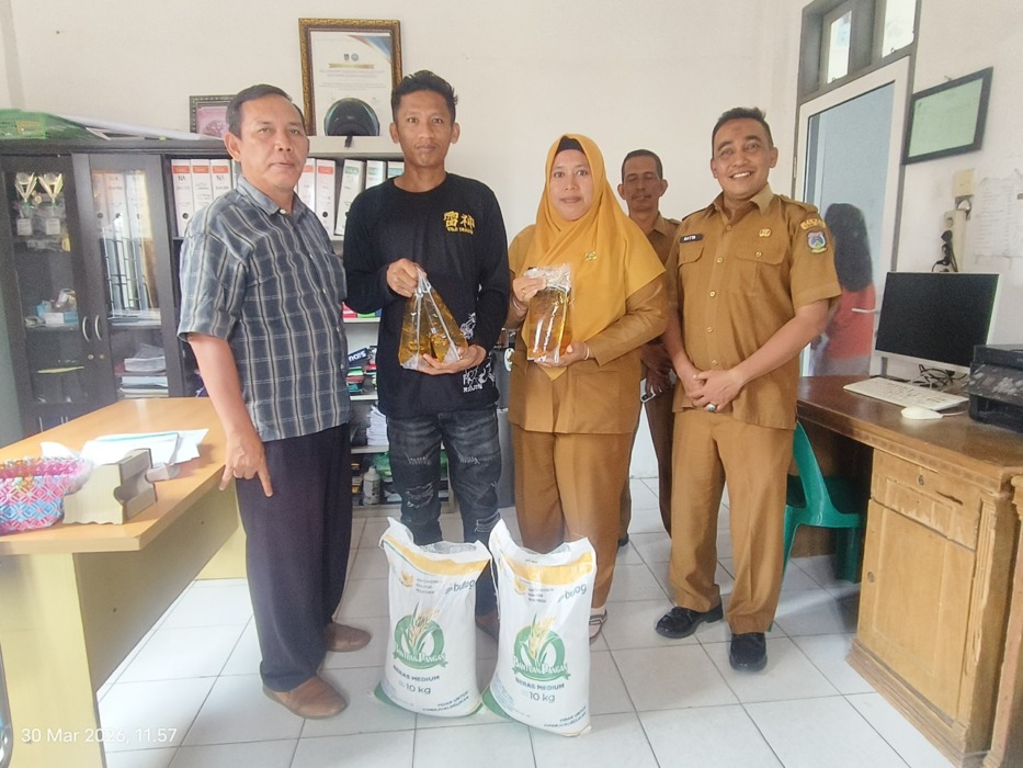 PENYERAHAN: Lurah Eka Sapitri, Kasi Terantib Kecamatan Hatta, dan jajaran kelurahan penyerahan sembako bansos kepada Heri Bima Utami Purba  di Kantor Lurah Tanjung Marulakhilir, Senin (30/3) Azan Purba/sumut Pos.